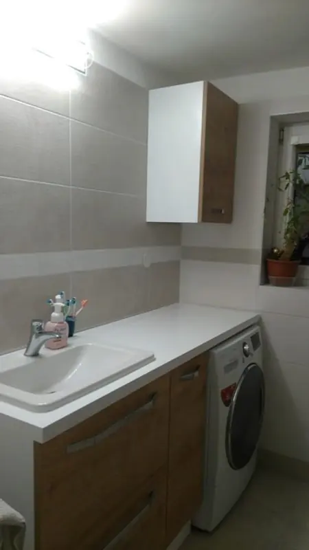 Koupelna s pračkou pod deskou vedle umyvadla