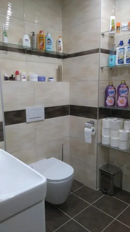 WC s béžovým obkladem a policemi